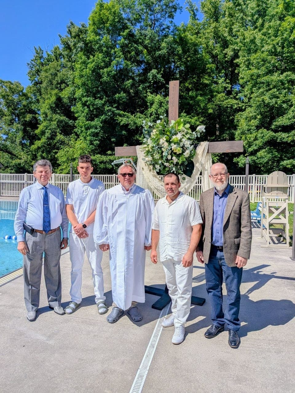 The pastors and a newly baptized believer by the cross